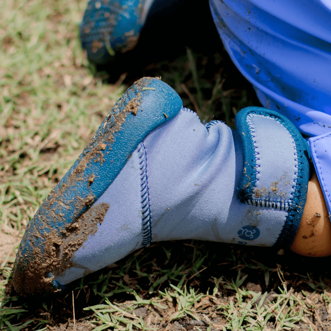 Barefoot wellies with flexible grip sole, toddler boots for early walkers in wet conditions - shown in a crawling position, covered with mud and dirt 