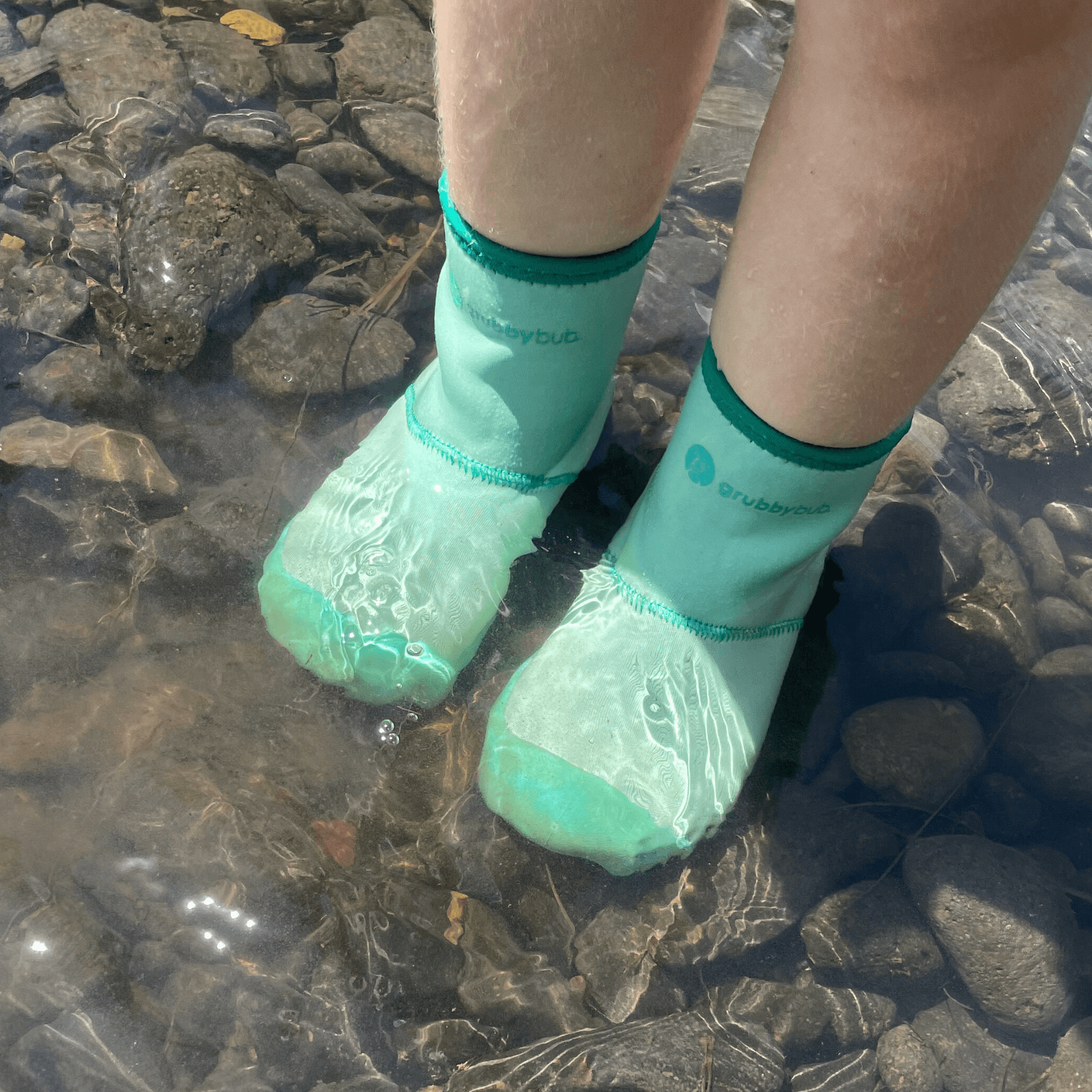 Toddler water shoes and pre walker wellies, soft sole barefoot boots for creek and outdoor play. Child in wee wellies walking in creek